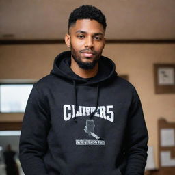 A detailed image of a brown-skinned barber wearing a stylish black hoodie that has the text 'The Clipper 45' boldly written on it.