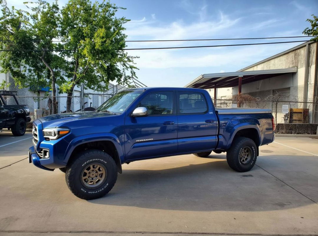 A customized blue Toyota Tundra pickup truck with a polished exterior, parked in a well-maintained outdoor area