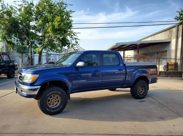 A blue Toyota Tundra pickup truck, modified with the front end design of a 2002 Toyota Land Cruiser 100