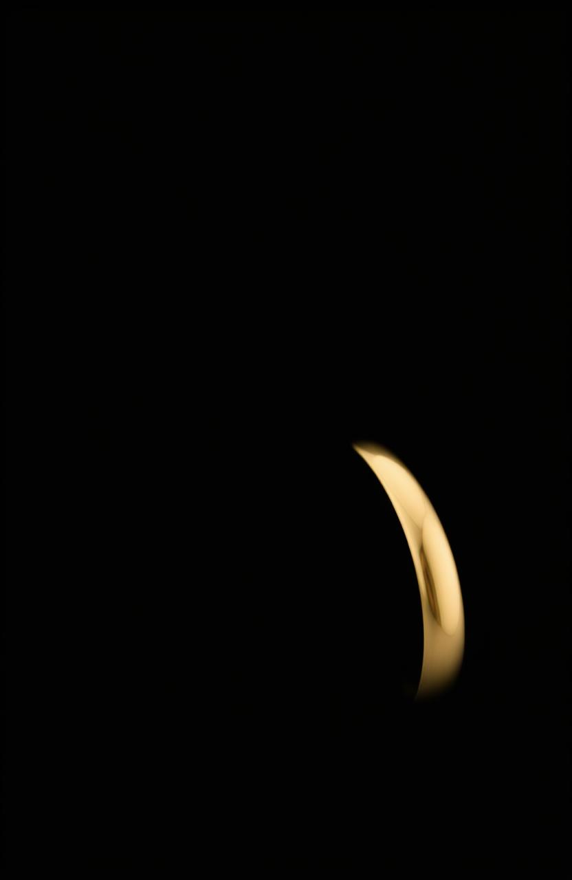 A simple gold ring positioned sideways against a mysterious black background, creating a striking contrast