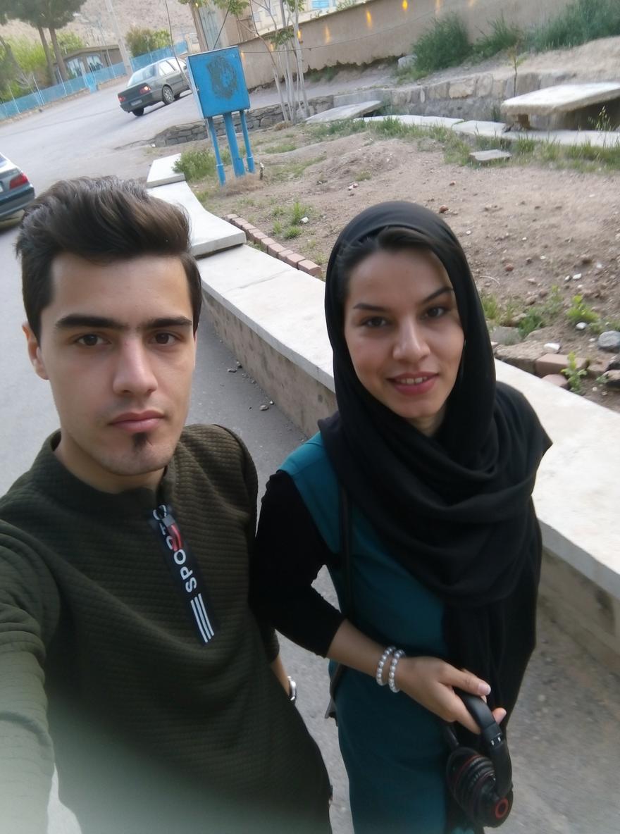 A portrait of two young adults walking together on a street