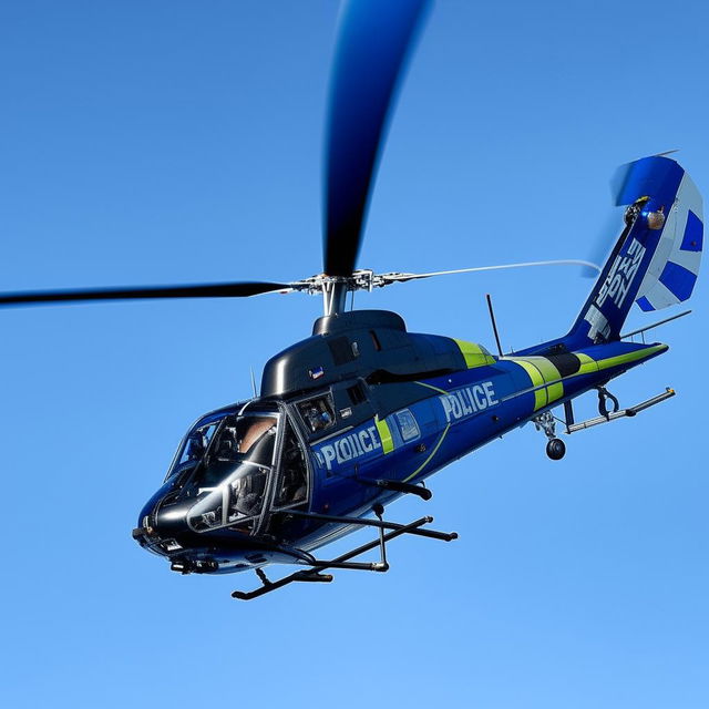 A police helicopter soaring in the sky, highlighting its advanced technology and streamlined design.