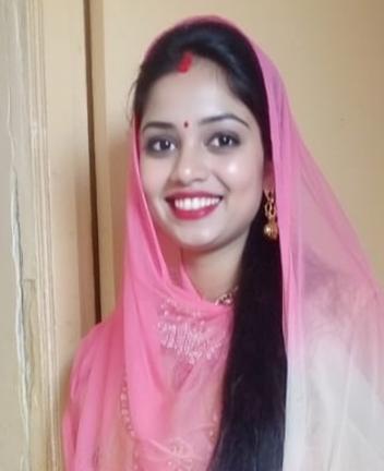 A young woman wearing a beautiful pink traditional outfit, adorned with intricate embroidery