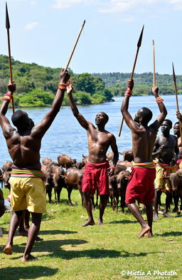 At the river shore, a vibrant scene of African men with strong physiques, joyfully dancing and singing heroic songs