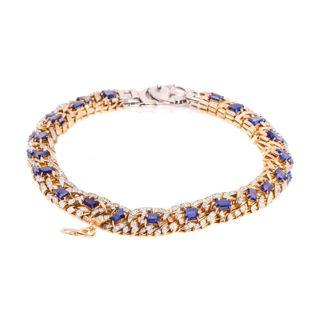 A Van Cleef and Arpels sapphire bracelet worn on a wrist, captured in a minimalistic product editorial photo.