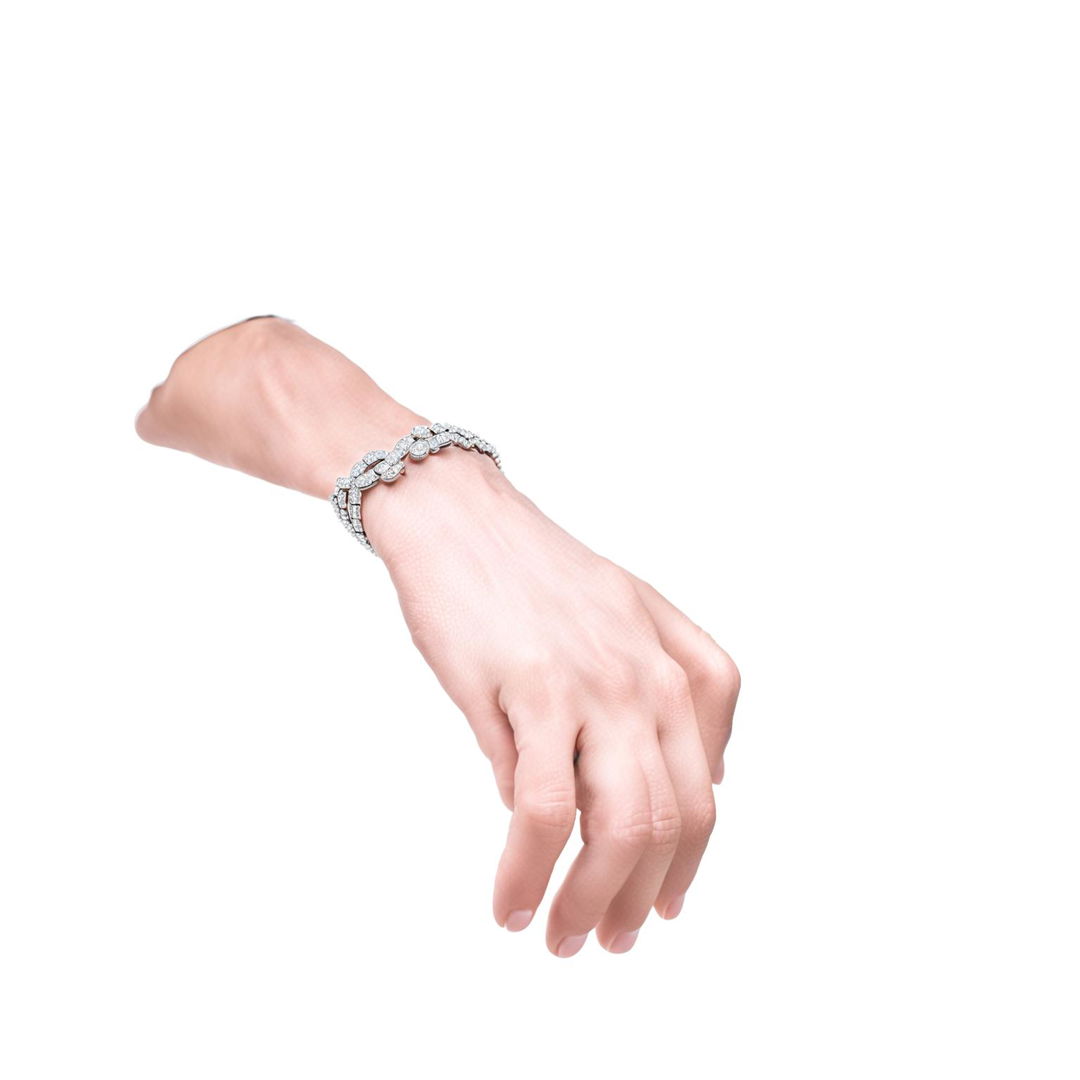 A close-up product editorial photo of a Van Cleef and Arpels tennis bracelet adorning a beautiful wrist.