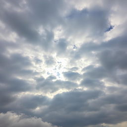 An expansive view of a cloudy sky filled with varying shades of gray and white clouds, some fluffy and others more textured, creating a dynamic and dramatic atmosphere