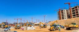 A bustling construction site filled with various heavy machinery including excavators, bulldozers, and cranes actively working