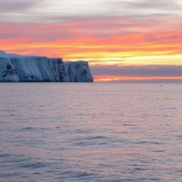 An expansive view of the Barents Sea at sunset, with serene waters stretching towards the horizon