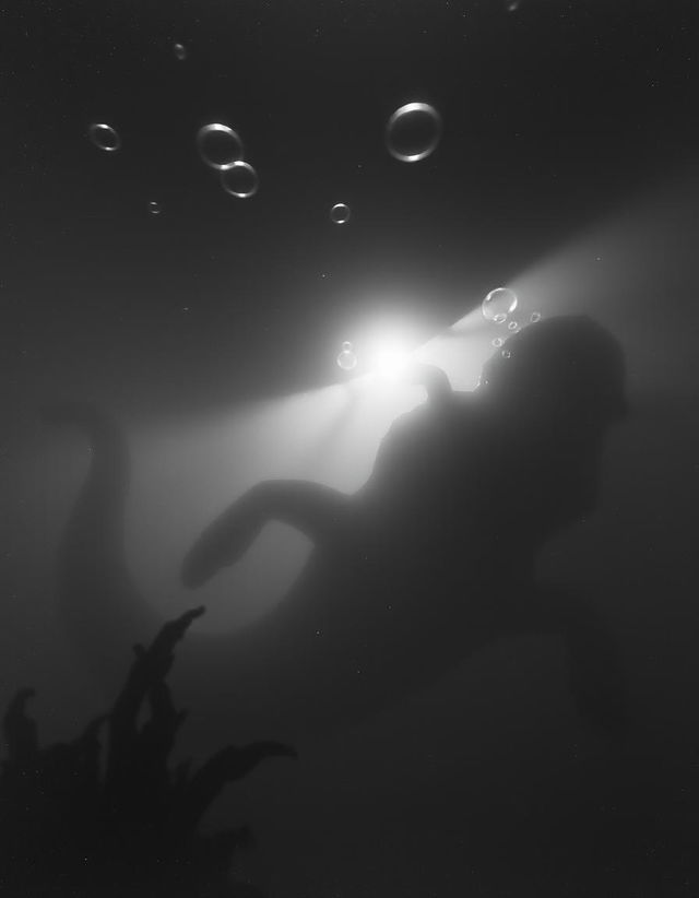 A grainy black and white photo capturing a sea monster lurking in the depths of the ocean