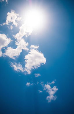 A vibrant blue sky with scattered fluffy white clouds, illuminated by the warm golden rays of the sun