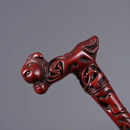 A maroon-colored wooden cane beautifully carved with intricate animal shapes throughout