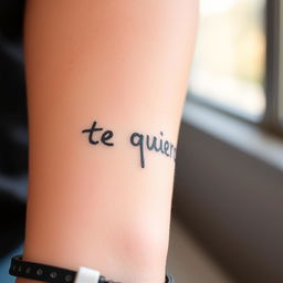 A close-up of a forearm tattooed with the phrase "te quiero" written in a casual, indie style using a black marker