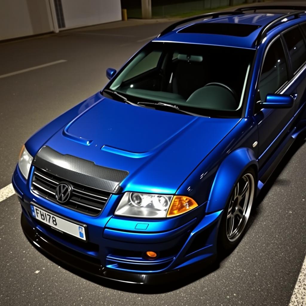 A blue 2001 widebody VW Passat R36 L wagon drift car with a carbon hood and aggressive aerodynamic features, parked at night