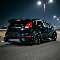 A sleek black Ford Fiesta ST with an extreme bodykit and a large rear spoiler, parked on a dimly lit highway at night
