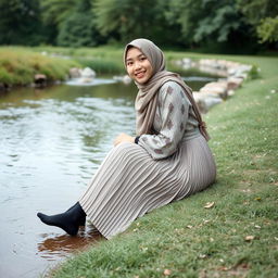 A girl wearing a luxurious hijab and a beautifully patterned abaya sits gracefully on the grass beside a tranquil water stream