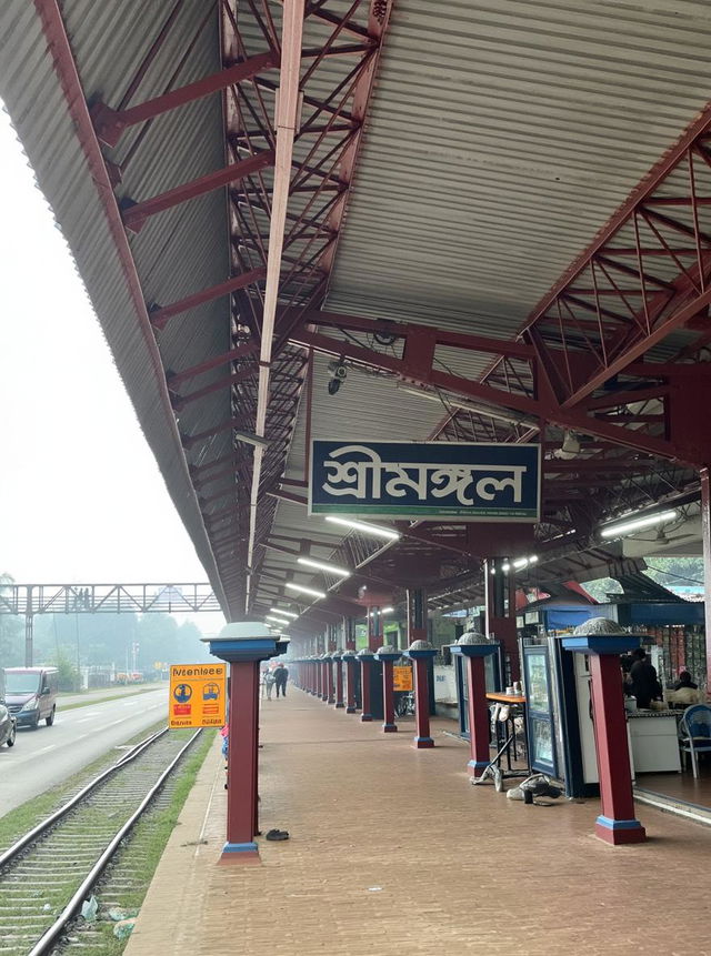 A vibrant scene at a train station named 'শ্রীমঙ্গল' with a long platform filled with diverse groups of people