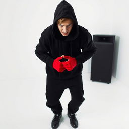 An angry teenager dressed entirely in black, wearing black shoes and a black hoodie with the hood up, his face partially obscured