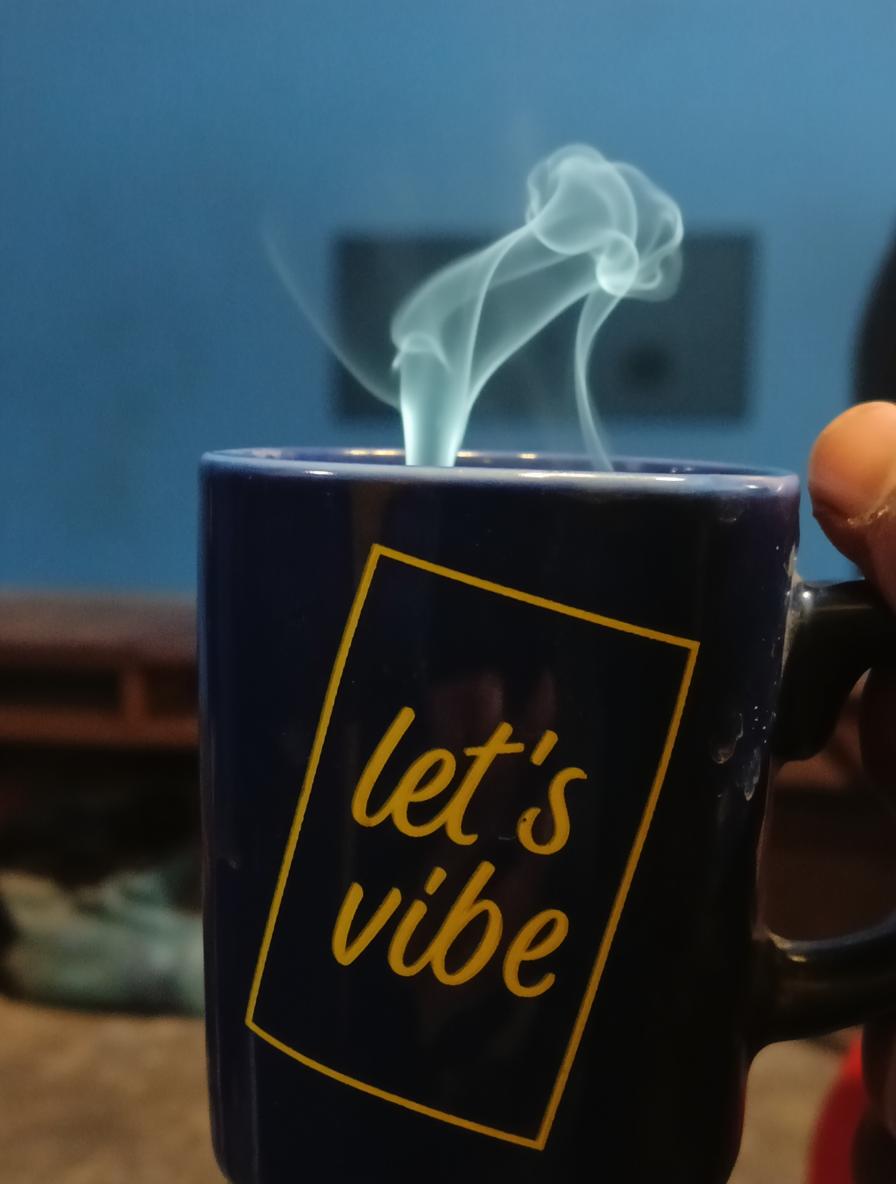 A close-up shot of a blue mug with the words "let's vibe" printed on it in a yellow rectangle