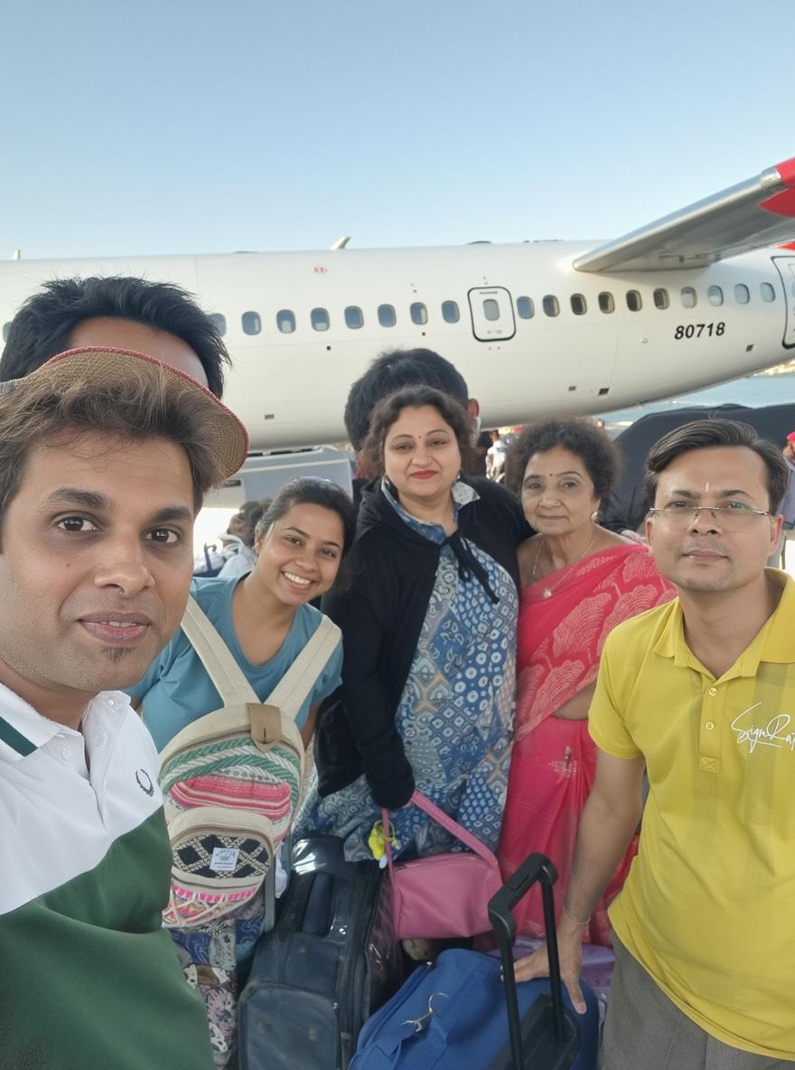 A vibrant scene capturing a group of five friends or family members at a busy train station, all smiling and posing for a photo amidst various luggage and travelers