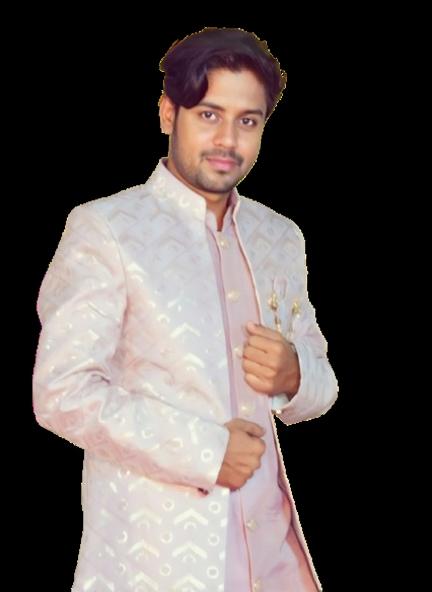 A man posing confidently in a traditional Indian outfit that is intricately designed with subtle patterns