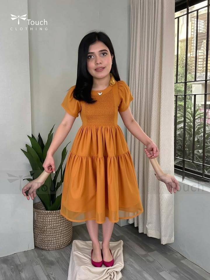 A fashionable young woman posing elegantly in an indoor setting, showcasing a stylish outfit