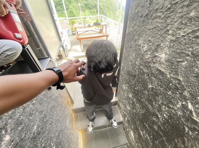 A person standing on a staircase, with a focus on the downward perspective