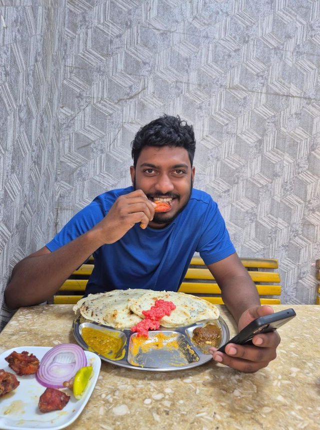 A young man enjoying a delicious South Indian meal at a cozy cafe, sitting casually at a table