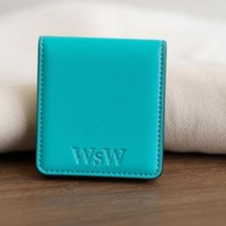 A stylish, modern wallet in a vibrant turquoise color, with a sleek design that prominently features the letters 'WsW' embossed on the bottom