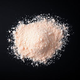 A mound of pink salt powder spread out on a black background, showcasing the delicate texture and color of the salt