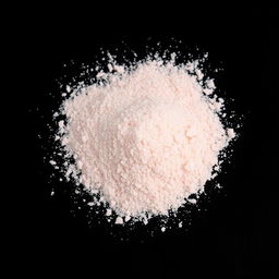 A pile of pink salt powder spilled on the ground, with no other objects present in the image