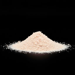 A mound of pink salt powder spilled on a flat surface, with nothing else in the image, and a completely black background