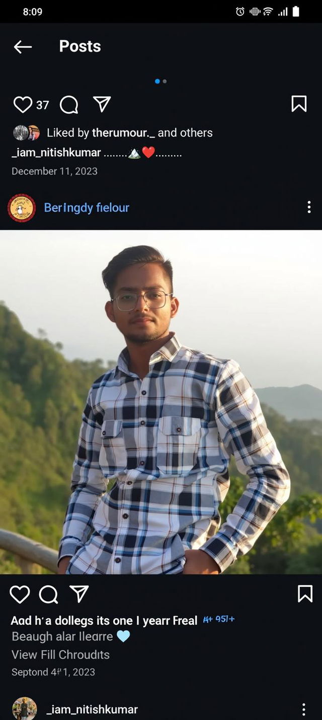 A young man with stylish glasses, wearing a plaid shirt, standing confidently against a picturesque mountainous background