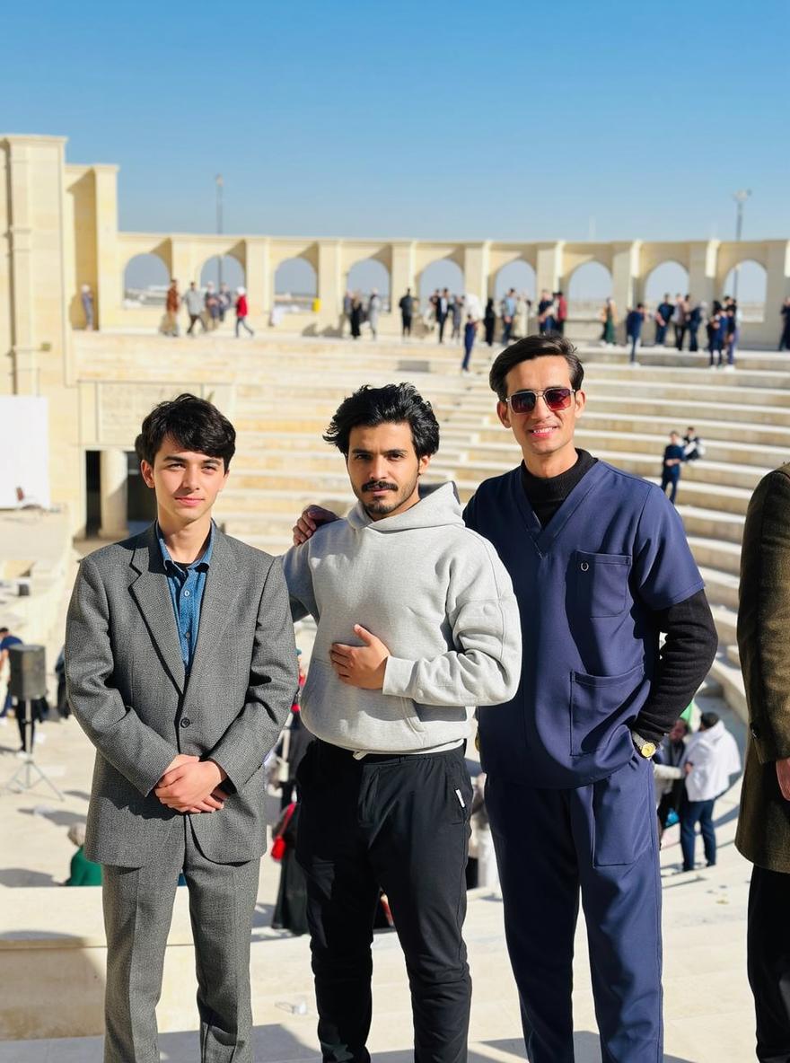 A group of three young men standing confidently on a grand set of stairs at an outdoor location