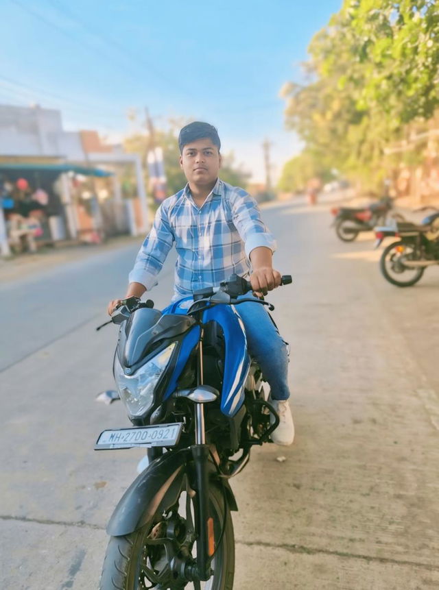 A young man confidently riding a stylish motorcycle on a sunny street