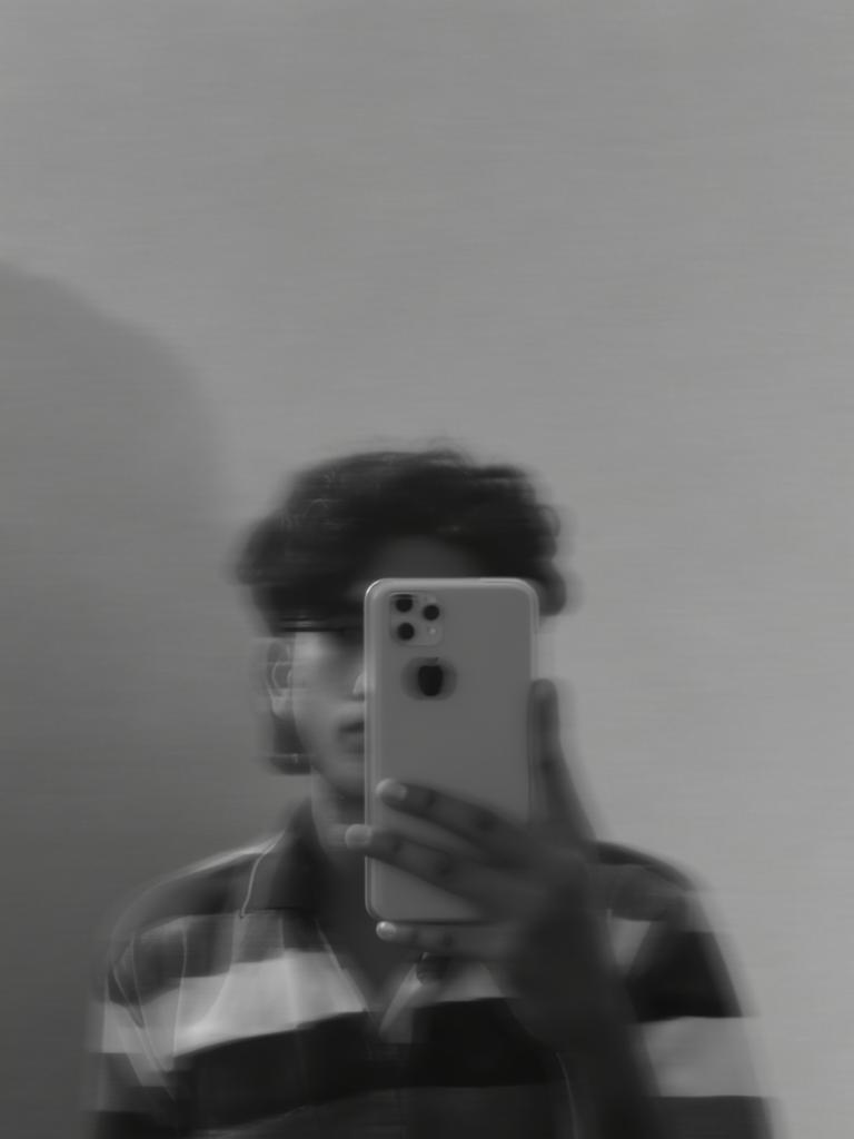 A blurred black and white image of a person holding an iPhone in front of their face, dressed in a horizontal striped shirt