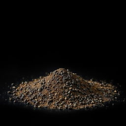 A pile of black pepper powder spilled on the ground, viewed from a frontal perspective