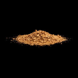 A pile of cinnamon pieces scattered on the ground, forming a small hill