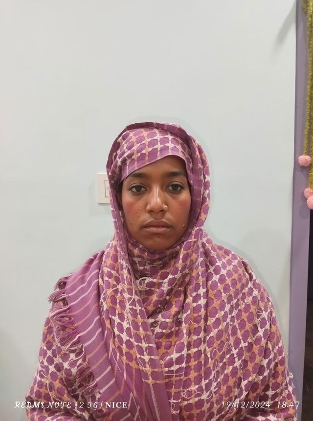 A portrait of a woman wearing a colorful, intricately patterned scarf