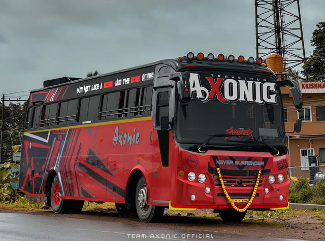 A vibrant red and black bus adorned with striking graphics and markings, positioned prominently on a road