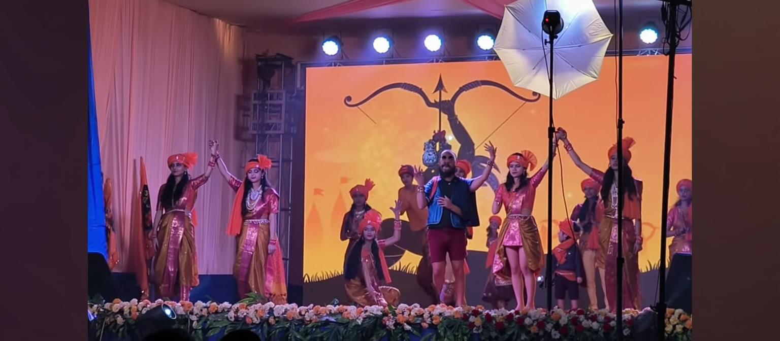 A brightly colored stage performance showcasing traditional dancers in vibrant attire, with intricate designs and patterns