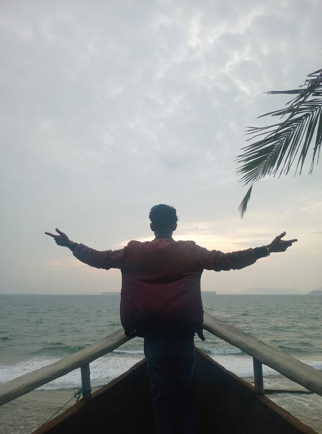 A man standing on the edge of a ship, facing away from the viewer