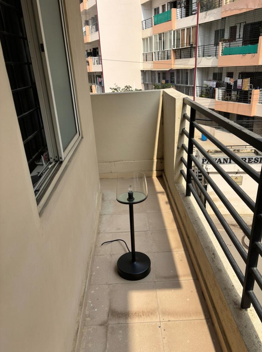 A modern balcony with a clean, minimalist design, featuring sleek black railings and large, bright windows