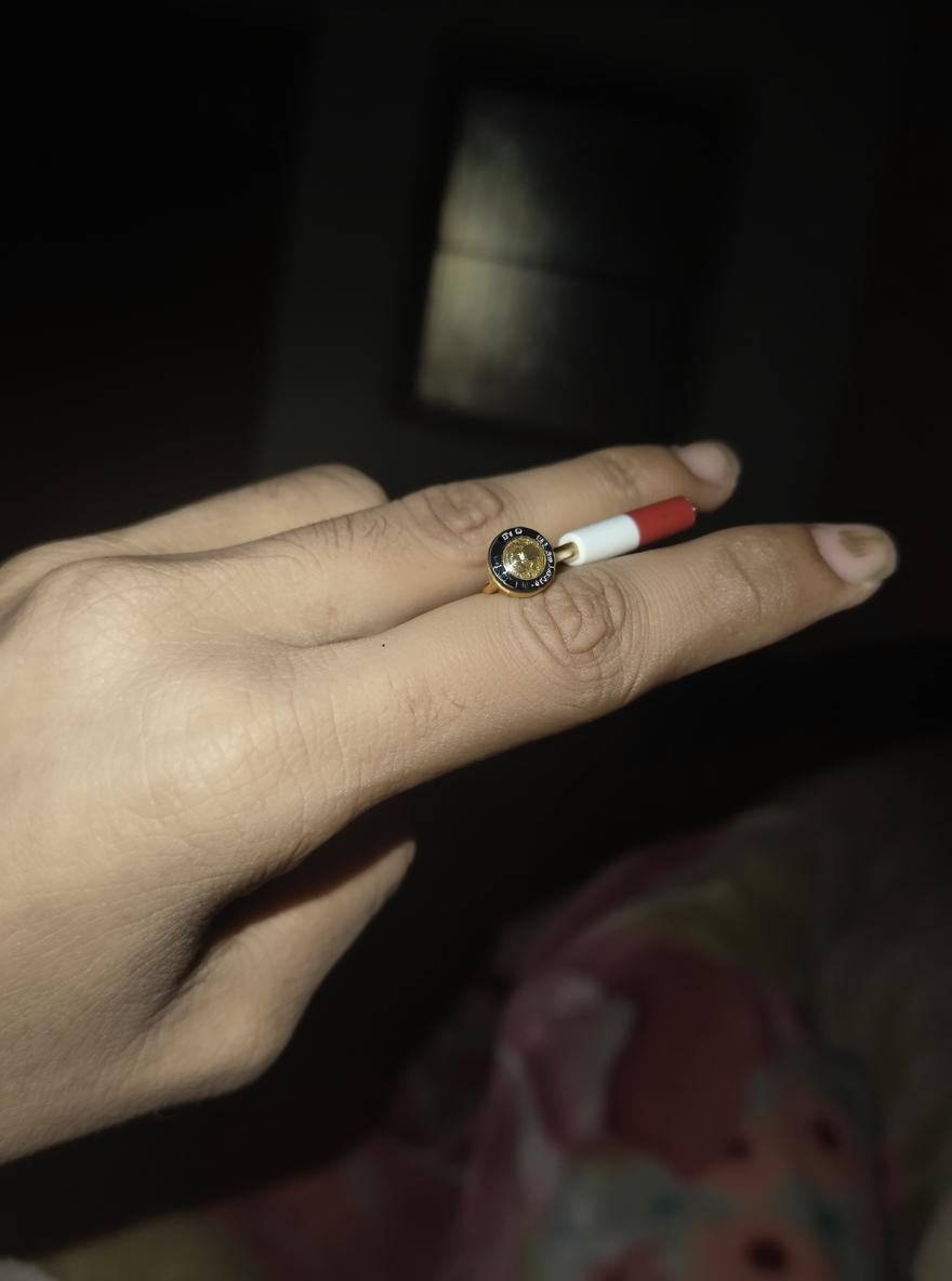 A close-up photo of a hand holding a cigarette