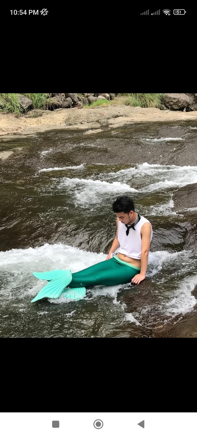 A serene scene featuring a young person sitting beside a gentle stream with clear, flowing water