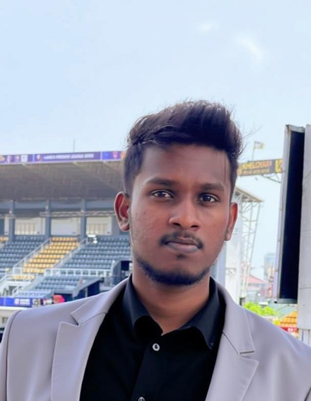 A young man standing outdoors in a sports venue