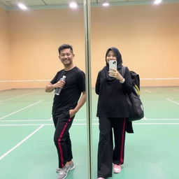 A man and woman posing for a mirror selfie in a badminton hall