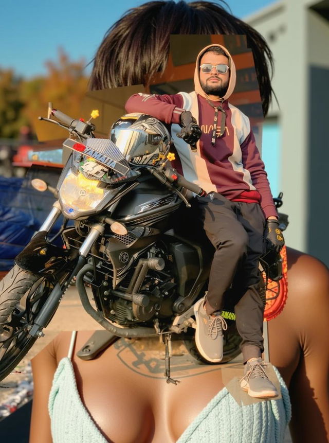 A stylish young man seated on his black motorcycle, displaying a cool demeanor