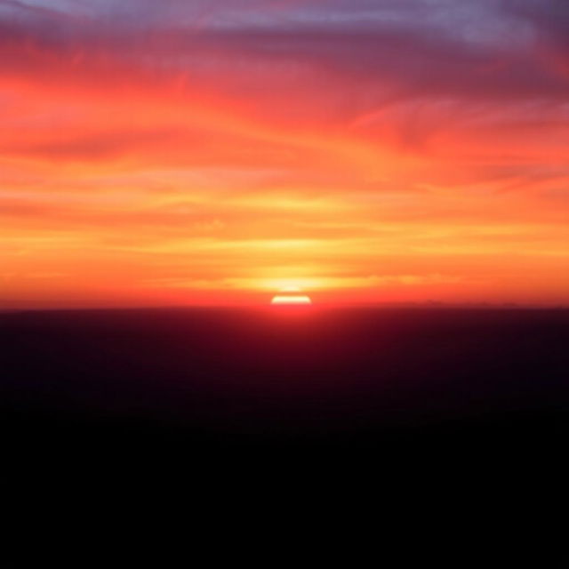 A beautiful sunset background, with vibrant colors of orange, purple, and pink hues blending across the sky, casting a warm glow