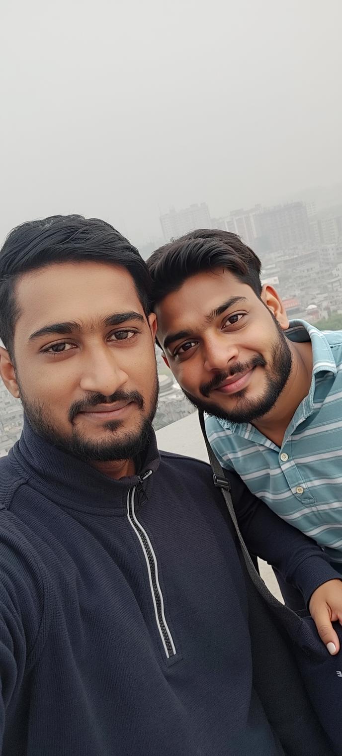 Two friends smiling for a selfie on a rooftop, with a blurry cityscape in the background